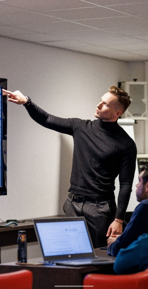 Een collega die een digitale toepassing toelicht op een scherm